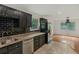 Well-lit kitchen featuring black cabinets, subway tile backsplash, granite countertops, stainless steel appliances and open floor plan at 3916 Green Forest Se Ln, Smyrna, GA 30082