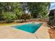 Sparkling pool is surrounded by lush greenery and a well-manicured yard, perfect for summer fun at 3916 Green Forest Se Ln, Smyrna, GA 30082