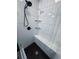 Sleek, tiled shower with built-in bench seating, rainfall shower head, glass shelving, and hexagon tile flooring at 3916 Green Forest Se Ln, Smyrna, GA 30082