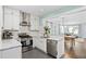 Modern kitchen with white cabinets, stainless steel appliances, subway tile backsplash, and open to the dining area at 1116 United Se Ave, Atlanta, GA 30316