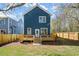 View of the home's back exterior, a spacious yard, and a wooden deck at 1183 Mobile Nw St, Atlanta, GA 30314