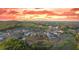 Expansive aerial view of the neighborhood showcasing homes nestled amidst rolling hills under a vibrant sunset sky at 231 Laurel Vista Dr, Canton, GA 30114
