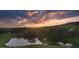 Scenic aerial view of a tranquil pond reflecting the colorful sunset sky, surrounded by lush green landscape at 231 Laurel Vista Dr, Canton, GA 30114