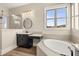 Bright bathroom featuring a soaking tub, large window, vanity, and a separate glass shower at 231 Laurel Vista Dr, Canton, GA 30114