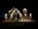 Beautiful new home with stone accents and illuminated outdoor lighting at night at 231 Laurel Vista Dr, Canton, GA 30114