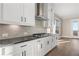 Bright kitchen features white cabinets, dark countertops, a gas cooktop, and stainless steel vent hood at 231 Laurel Vista Dr, Canton, GA 30114