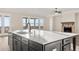 Kitchen island with sink, dishwasher, and generous quartz countertop, plus living room with stone fireplace at 231 Laurel Vista Dr, Canton, GA 30114