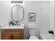 Charming half bath featuring a wooden vanity, an oval mirror, and neutral colors at 2849 Knotty Pine Ct, Buford, GA 30519