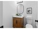 Charming half bath with a wooden vanity, stylish mirror, and modern lighting fixtures at 2849 Knotty Pine Ct, Buford, GA 30519