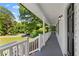 Covered porch with white railings, complemented by wooded views and natural light at 2849 Knotty Pine Ct, Buford, GA 30519