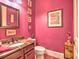 Pink half-bath with framed mirror, pedestal sink, toilet, and dark countertops at 351 Ne Washington Ne Ave # 307, Marietta, GA 30060