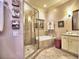 Bright bathroom with a walk-in shower, soaking tub, white cabinets, and marble countertops at 351 Ne Washington Ne Ave # 307, Marietta, GA 30060