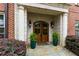 Stately stone entrance with arched double wood doors, lantern sconces, and lush potted ferns create a welcoming approach at 351 Ne Washington Ne Ave # 307, Marietta, GA 30060