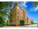 Elegant brick condo building featuring manicured landscaping, and patriotic American flags displayed on the front lawn at 351 Ne Washington Ne Ave # 307, Marietta, GA 30060
