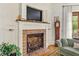 Cozy living room features a brick fireplace, a flat screen television, a grandfather clock and a comfortable green sofa at 351 Ne Washington Ne Ave # 307, Marietta, GA 30060