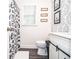 Stylish bathroom features a modern vanity, decorative wallpaper, and a shower with a patterned curtain at 1206 Tred Avon Sw Way, Lilburn, GA 30047