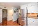 Spacious kitchen featuring stainless steel refrigerator, white cabinets, and hardwood floors at 1206 Tred Avon Sw Way, Lilburn, GA 30047