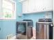 This laundry room features light blue walls, white cabinets, and modern washer and dryer units at 1206 Tred Avon Sw Way, Lilburn, GA 30047