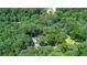 Lush, dense trees surround a home with a light-colored roof at 1216 Oleander Sw Dr, Lilburn, GA 30047