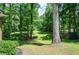 Expansive backyard featuring a well-maintained lawn and mature trees providing shade and privacy at 1216 Oleander Sw Dr, Lilburn, GA 30047