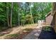 Image of the brick walkway in the backyard along a wooded lot at 1216 Oleander Sw Dr, Lilburn, GA 30047