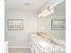 Bathroom with a double granite sink vanity, neutral walls, and modern lighting fixtures at 1216 Oleander Sw Dr, Lilburn, GA 30047