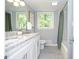 Well-lit bathroom featuring a granite countertop, double sink vanity, and tiled shower and tub at 1216 Oleander Sw Dr, Lilburn, GA 30047