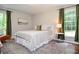 A cozy bedroom with natural light from two windows and neutral decor with accents of green at 1216 Oleander Sw Dr, Lilburn, GA 30047