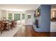 Bright dining room with hardwood floors, large windows, and a painted brick fireplace at 1216 Oleander Sw Dr, Lilburn, GA 30047