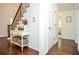A charming entryway featuring hardwood floors, stairs, decorative table, and access to a bathroom at 1216 Oleander Sw Dr, Lilburn, GA 30047