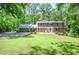 Two-story brick home with a well-manicured lawn and mature trees in a serene, wooded setting at 1216 Oleander Sw Dr, Lilburn, GA 30047