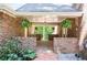A view of the brick-paved front porch featuring ferns, columns, and a view of the wooded area at 1216 Oleander Sw Dr, Lilburn, GA 30047