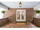 View of the brick porch with hanging ferns and view through french doors at 1216 Oleander Sw Dr, Lilburn, GA 30047