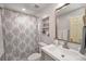 Cozy bathroom featuring shower with patterned curtain, grey vanity, and decorative recessed shelving at 132 East Ne Dr, Atlanta, GA 30305