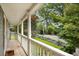 Picturesque porch with white railing overlooking a beautifully landscaped front yard and quiet street at 132 East Ne Dr, Atlanta, GA 30305