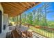 Covered back porch with a wooden table and bench, perfect for dining while overlooking a lush green landscape at 23 Sunset Se Rdg, Cartersville, GA 30121