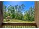 View of a lush backyard and wooden playset from the back porch, offering a serene and inviting outdoor space at 23 Sunset Se Rdg, Cartersville, GA 30121