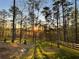Scenic backyard with trees, green lawn, a bench and a wooden fence under sunlight at 23 Sunset Se Rdg, Cartersville, GA 30121