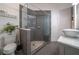 Modern bathroom showcasing a glass-enclosed shower with gray tiling, pebble floor, built-in bench, toilet, and floating vessel sink at 23 Sunset Se Rdg, Cartersville, GA 30121