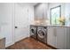 Functional laundry room featuring front-load washer and dryer, granite countertops, and ample cabinet space with modern fixtures at 23 Sunset Se Rdg, Cartersville, GA 30121