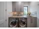 Well-equipped laundry room featuring a front-load washer and dryer, granite countertop, sink, and ample cabinet space at 23 Sunset Se Rdg, Cartersville, GA 30121
