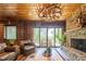 Living room with stone fireplace, antler chandelier, log walls, and sliding glass doors to the deck at 23 Sunset Se Rdg, Cartersville, GA 30121