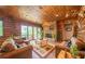 Living room with stone fireplace, antler chandelier, wood walls, and sliding glass doors to the deck at 23 Sunset Se Rdg, Cartersville, GA 30121