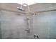 Modern walk-in shower featuring gray tile, a rainfall showerhead, handheld sprayer, and sleek fixtures for a luxurious experience at 23 Sunset Se Rdg, Cartersville, GA 30121
