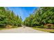 Street view of community entrance lined with mature trees and stone signage at 23 Sunset Se Rdg, Cartersville, GA 30121
