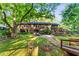 The lush backyard has a brick home, stone pathway, wooden bridge, and patio at 2511 Oak Ave, Tucker, GA 30084