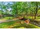 Lush backyard featuring a wooden bridge, mature trees and landscaping at 2511 Oak Ave, Tucker, GA 30084