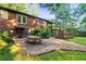 Backyard features a brick home, stone patio, picnic table, and wooden staircase at 2511 Oak Ave, Tucker, GA 30084