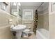 Charming bathroom with tiled walls, pedestal sink, and vintage-style fixtures at 2511 Oak Ave, Tucker, GA 30084
