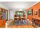 Inviting dining room with wood floors, chandelier, orange accent wall and cabinet for storage at 2511 Oak Ave, Tucker, GA 30084